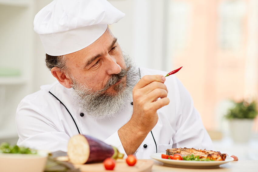 senior-chef-holding-chili-pepper-EYKDMKE-3.jpg